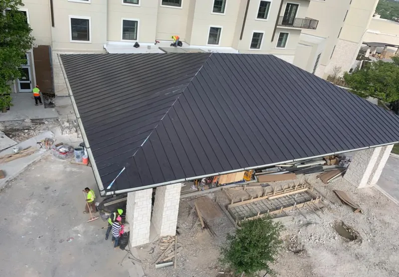 Metal roofing installation team working on a commercial building in Tittabawassee